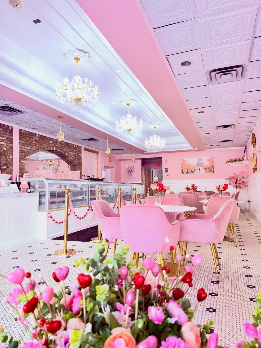 Crystal chandelier sconces on pink wall with gold mirrors