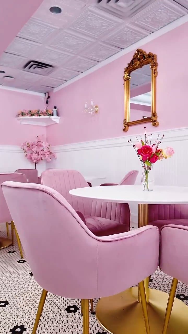Pink velvet dining chairs and round table with flower arrangement